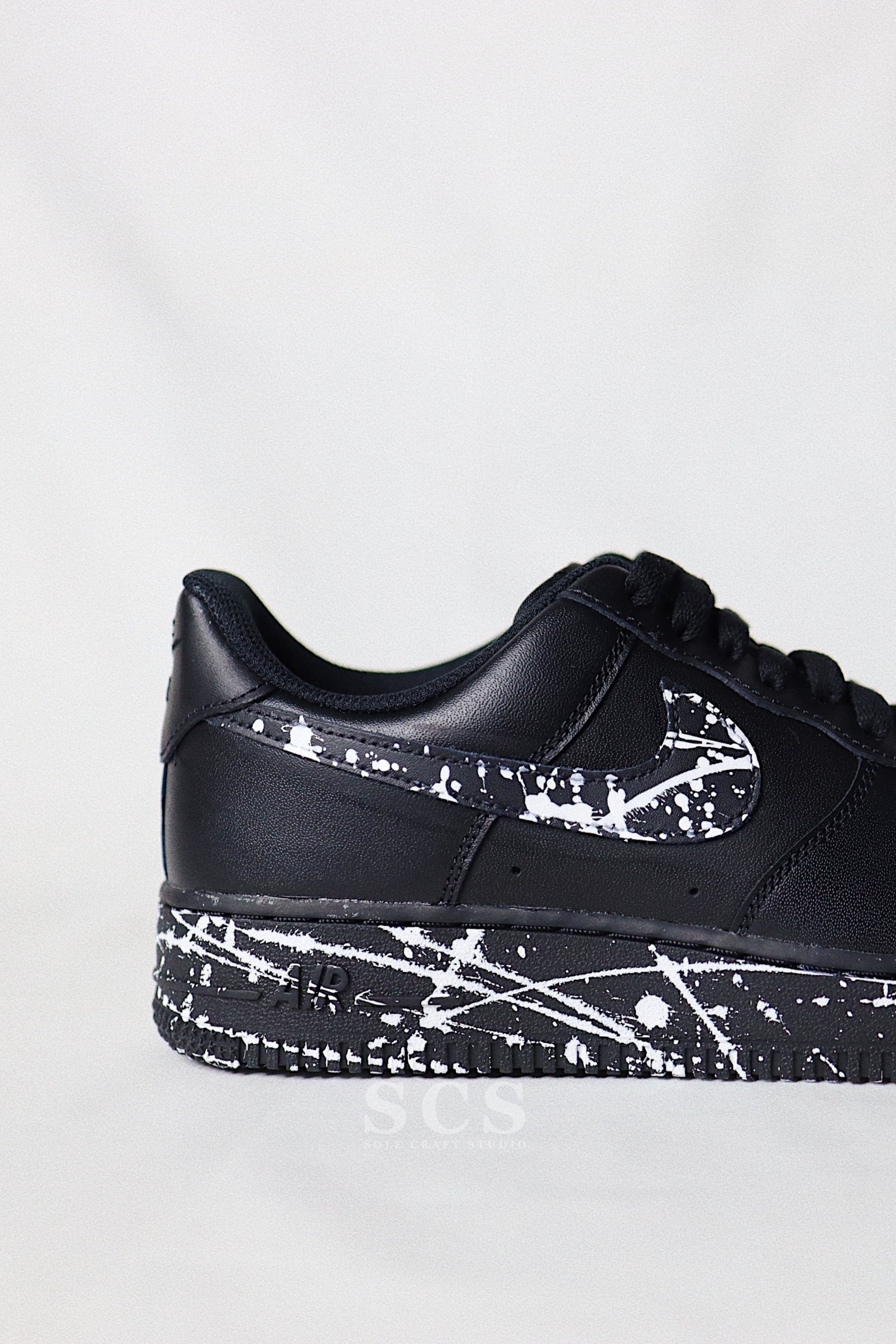 black air force 1 with paint splatter